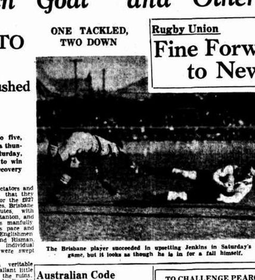 Newspaper photograph captioned One Tackled, Two Down, showing Emlyn Jenkins upset by a Brisbane tackler