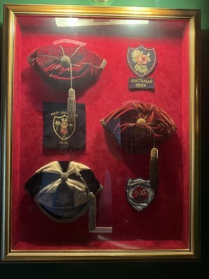 Framed display of Emlyn Jenkins's surviving rugby league caps and badges