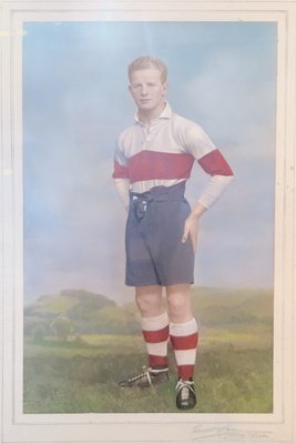 Hand-tinted portrait photograph of Emlyn Jenkins in rugby kit